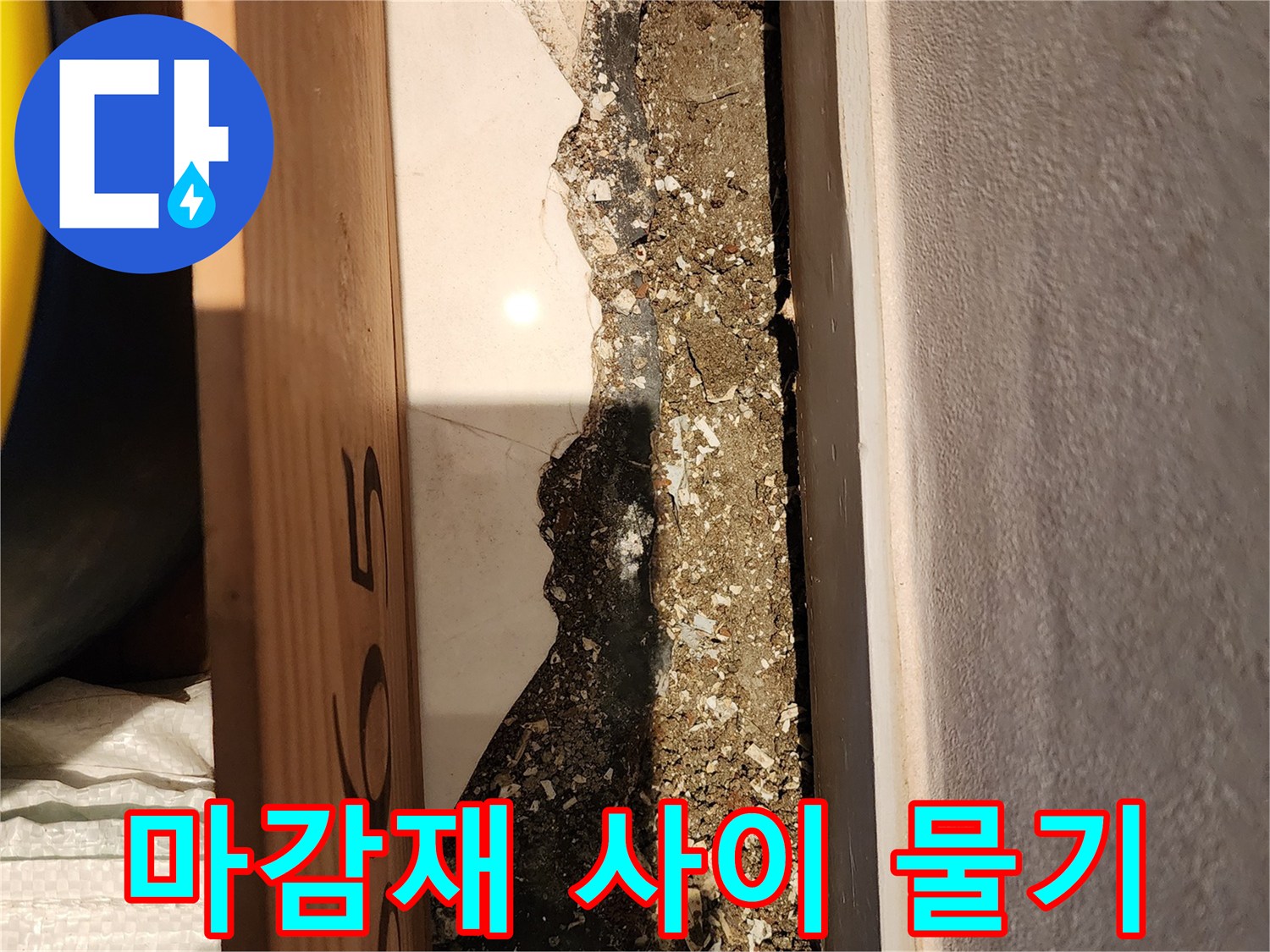 하얀 타일 아래쪽의 어두운 습기 자국