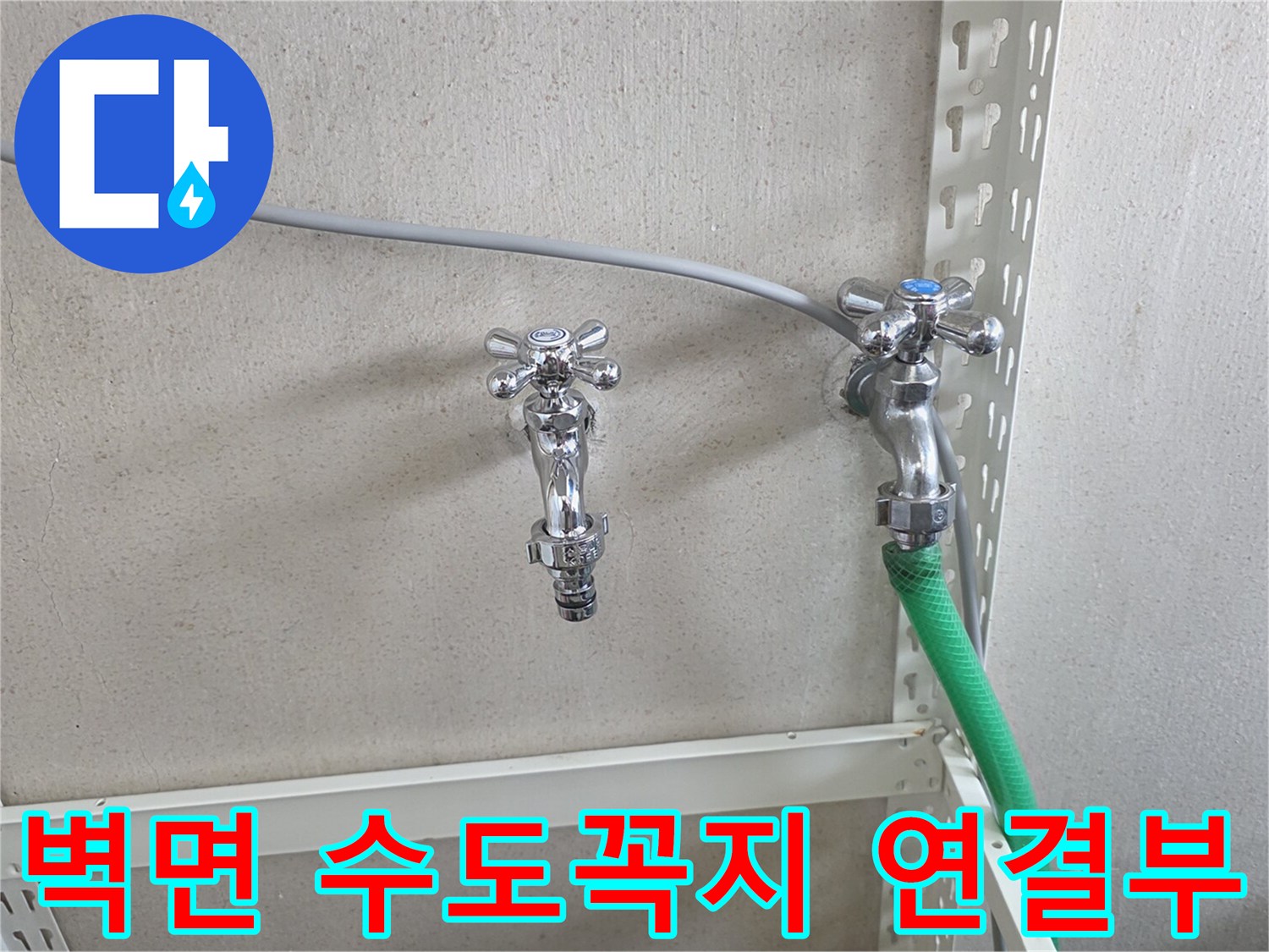 벽면에 고정된 금속 수전과 초록색 호스 연결 상태