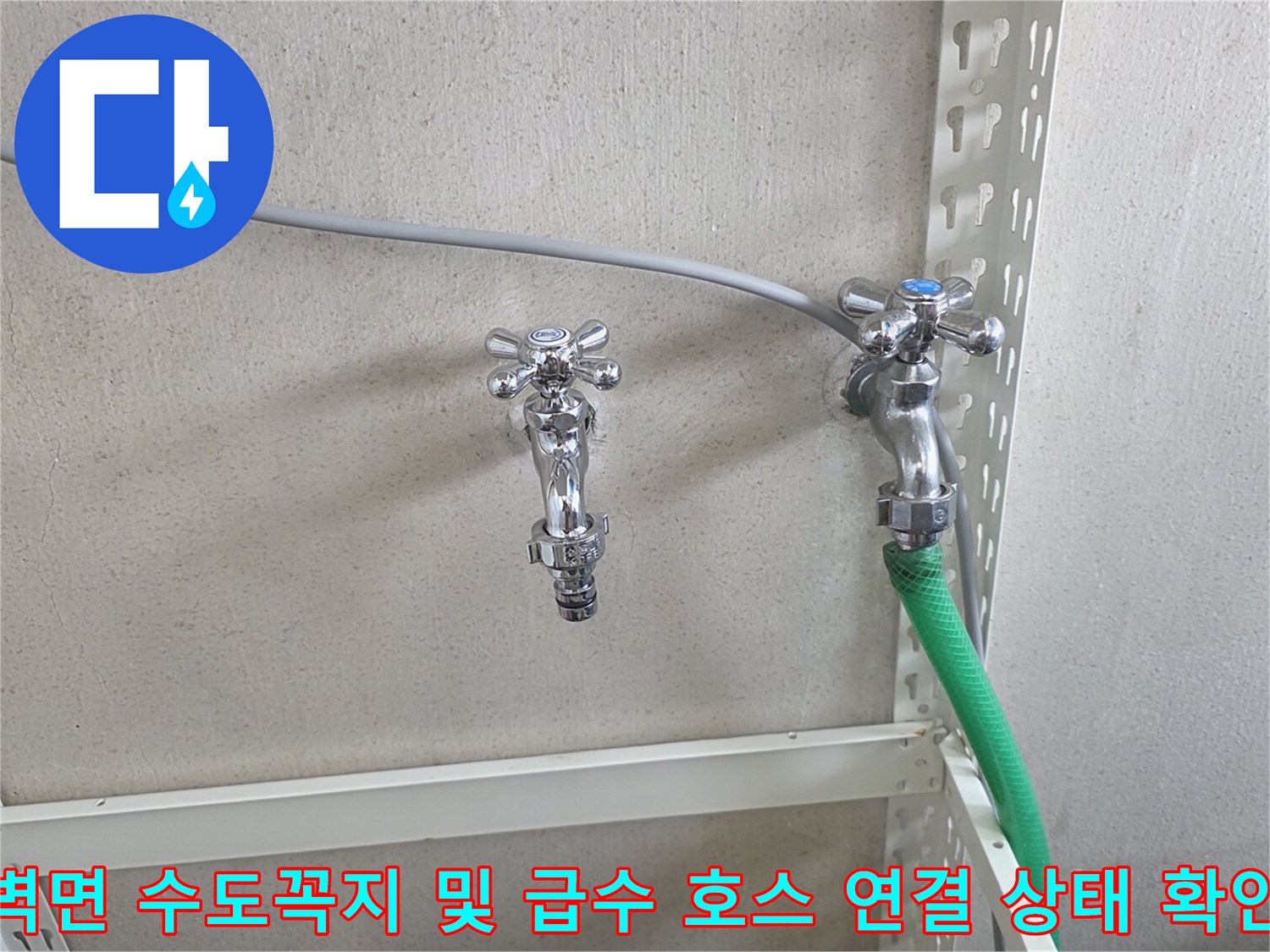 은색 금속 수전-초록색 호스가 연결된 배관 부위