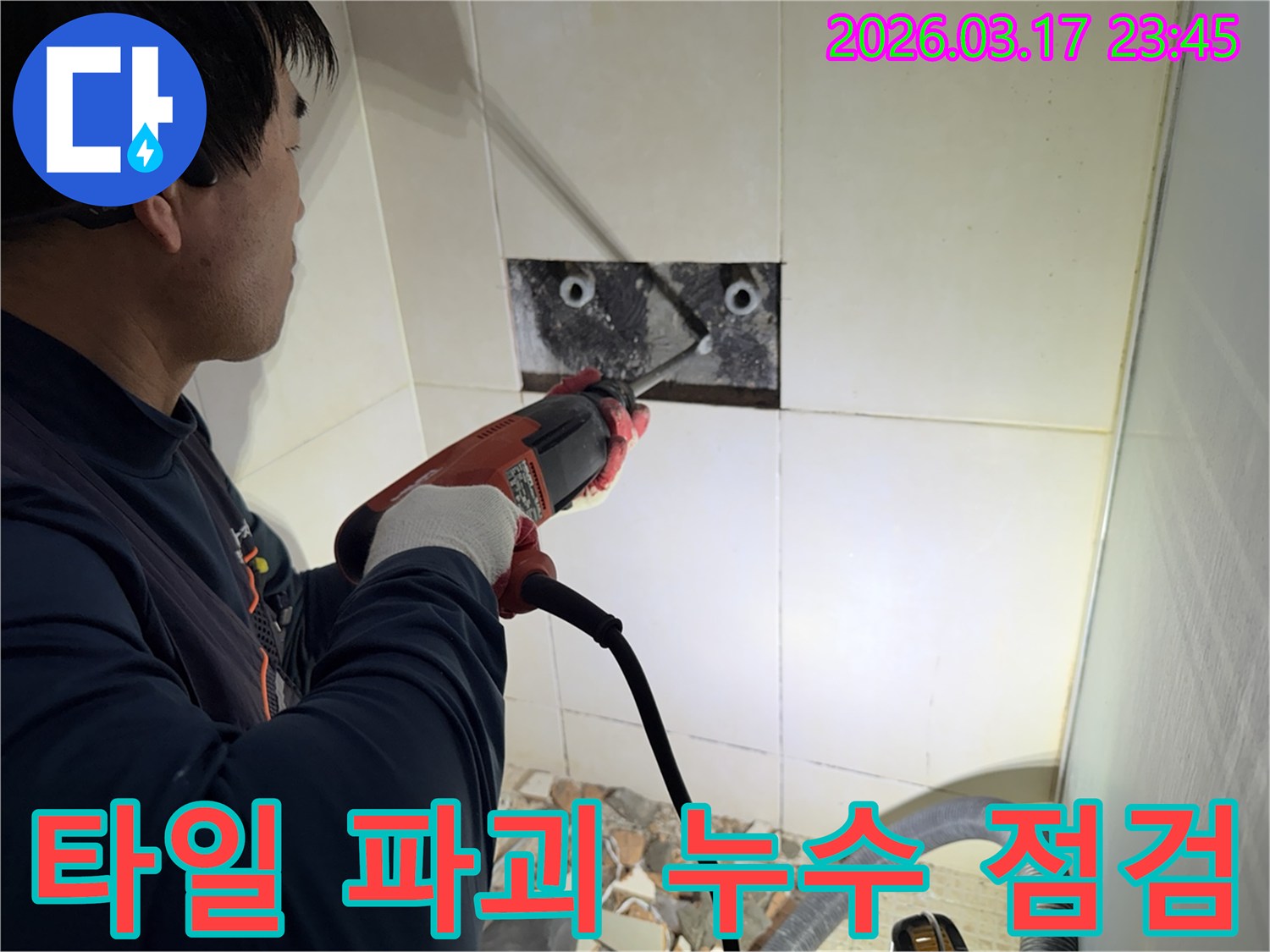 누수 전문가가 아파트 벽면 타일을 파괴하여-숨겨진 배관의 누수 지점을 정밀하게 점검하는 작업 현장입니다.