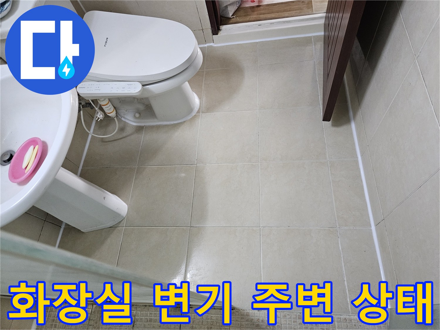 변기와 세면대 사이의 타일 마감 상태를 보여주는 사진입니다.