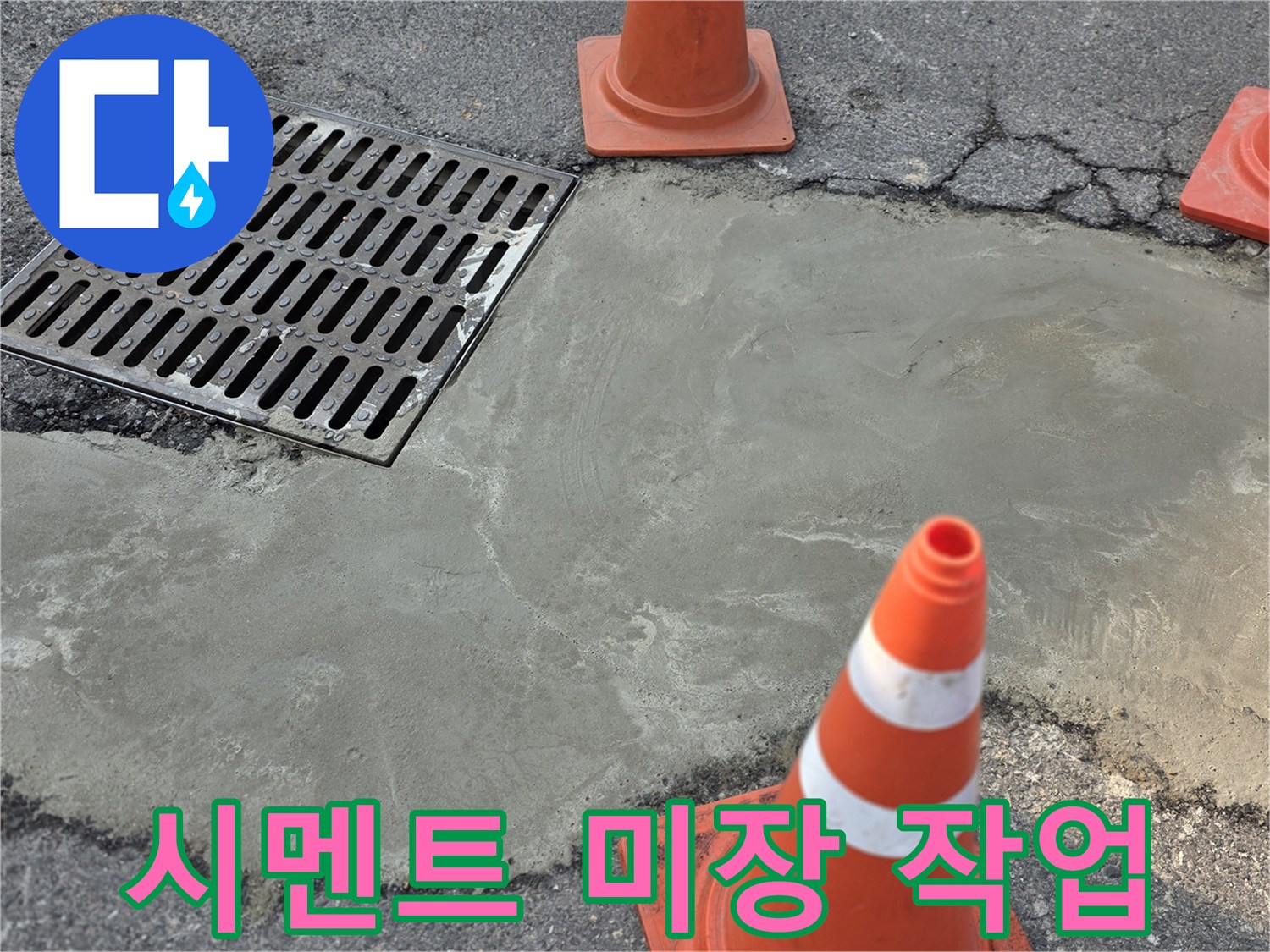 배수구 옆 시멘트로 덮인 도로 파손 부위