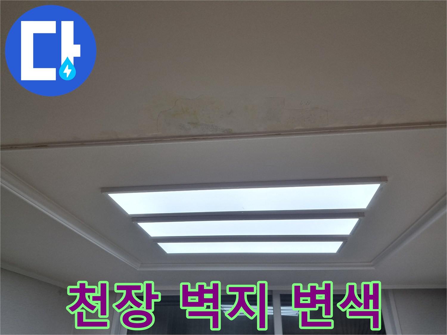 천장 조명 패널 주변에 나타난 누수로 인한 도배지 변색 부위