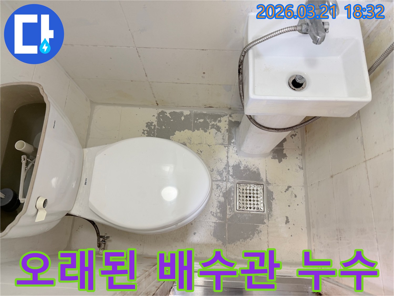 오래된 아파트 화장실 바닥에서-배수관 문제로 인해 발생한-타일 손상과 물 스밈 현장