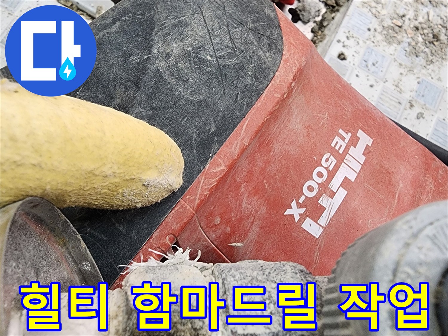 배관 굴착을 위해 사용 중인 힐티 함마드릴과 파쇄된 타일 조각