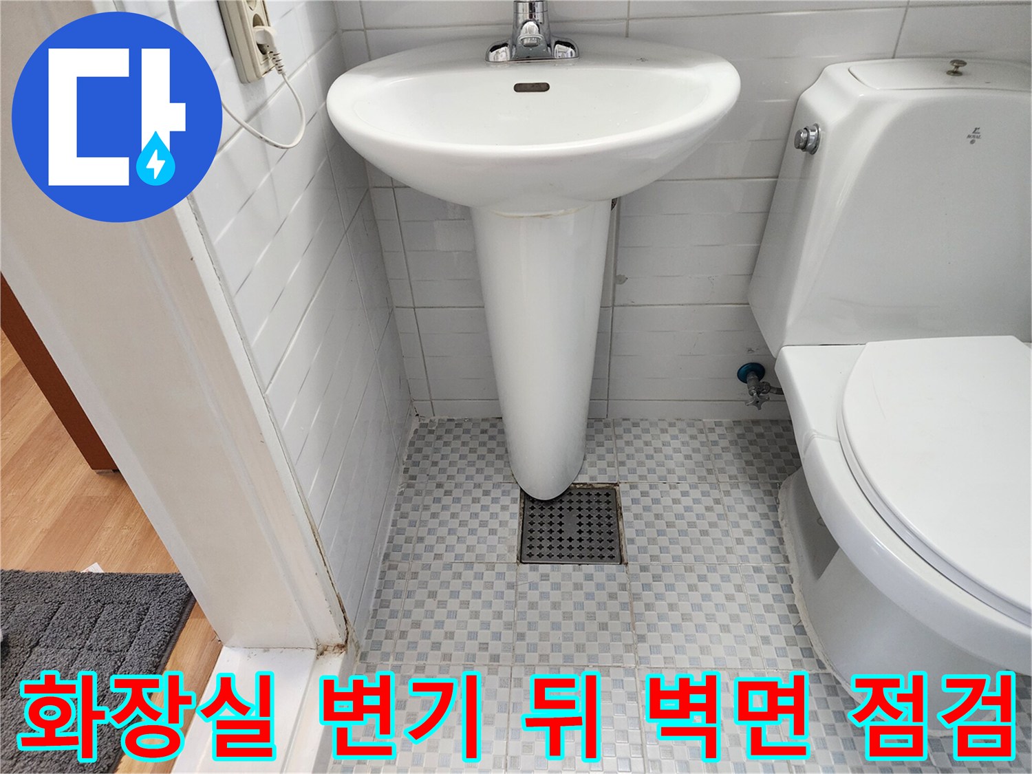변기 뒷부분의 타일 벽면과 하단 배수구 모습