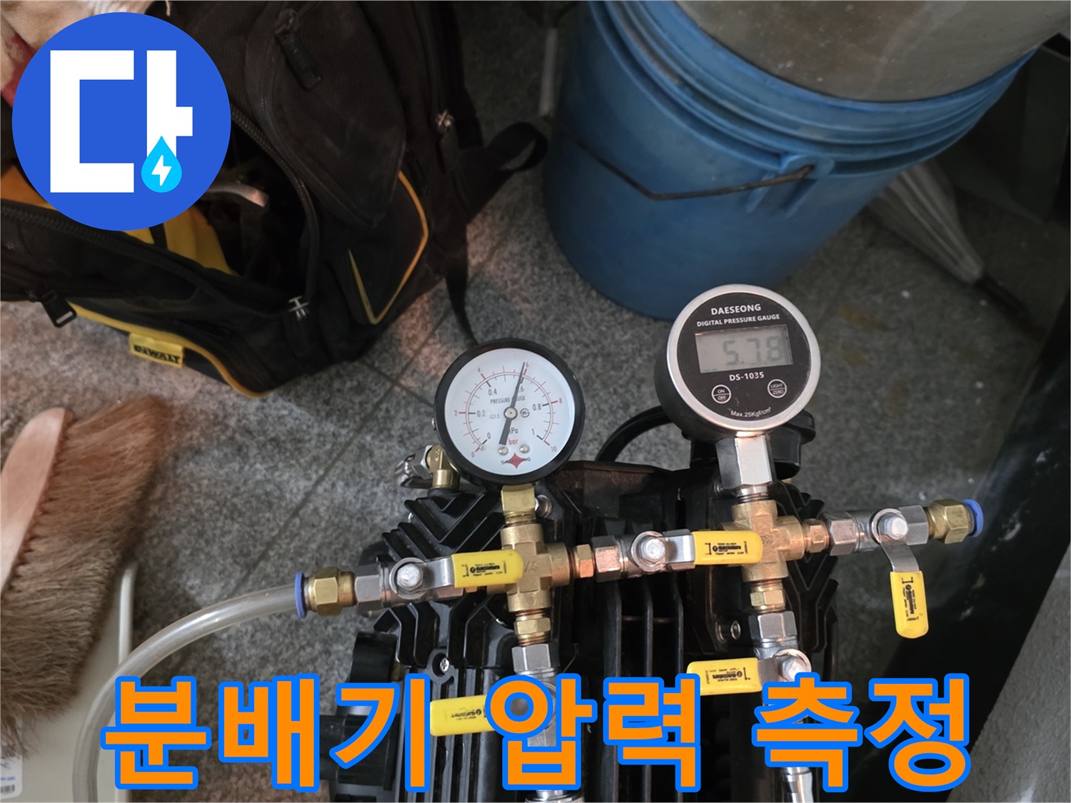 금색 부속으로 연결된 분배기 라인의 압력 게이지 설치 장면