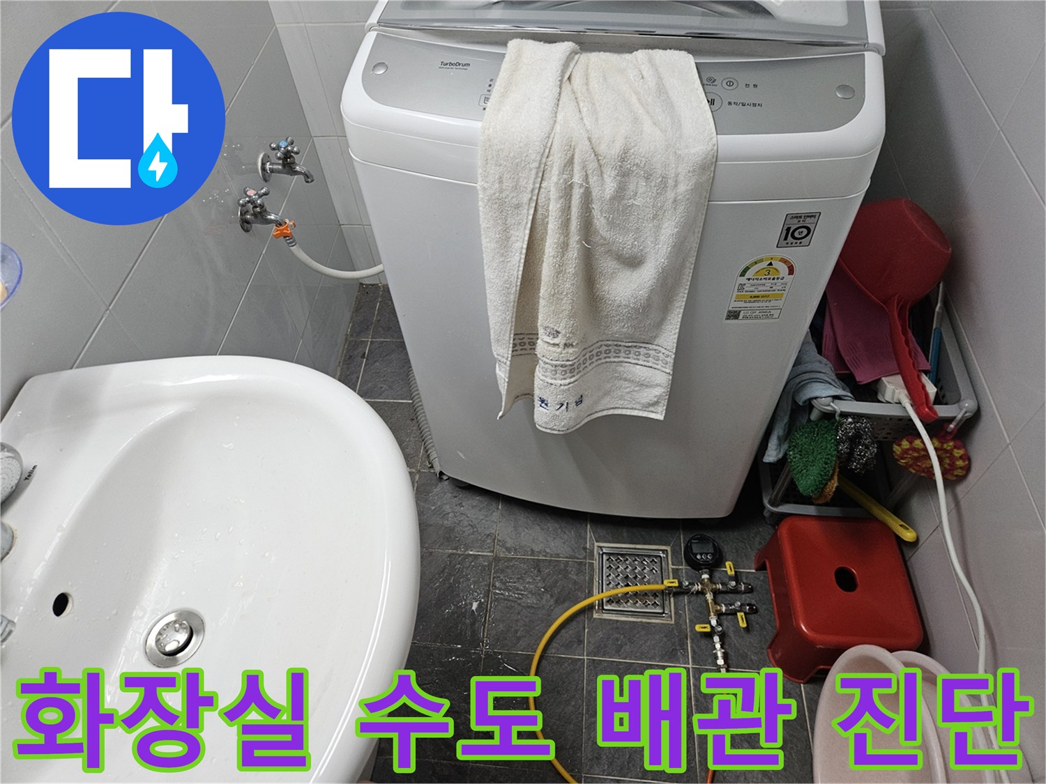세탁기 수전 부근에 압력계를 설치하여 배관 내 공기압을 주입하는 장면입니다.