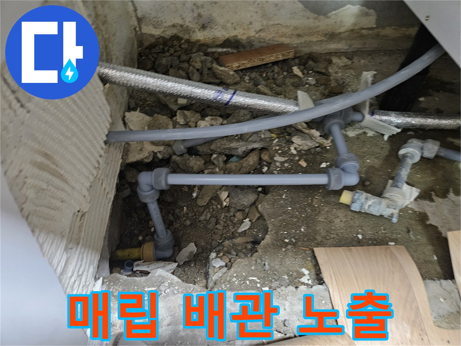 콘크리트 층 아래에 드러난 회색 PVC 및 금속 배관