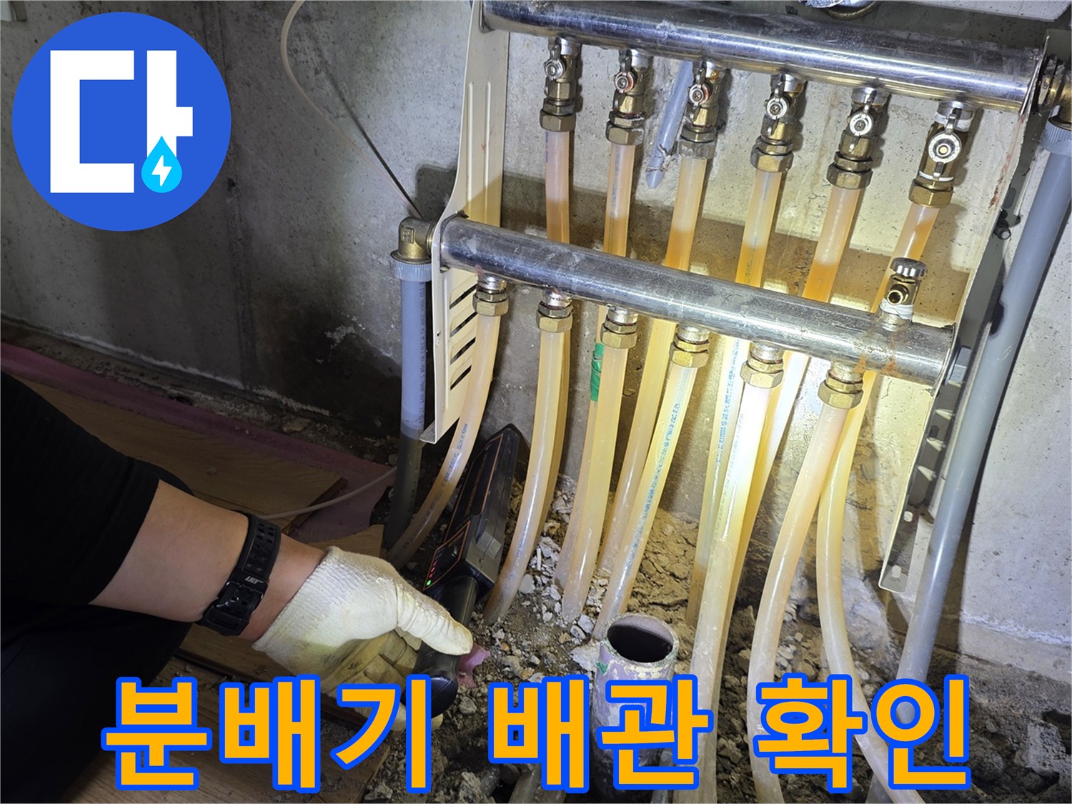 싱크대 하단의 난방 분배기와 연결된 유연한 호스들