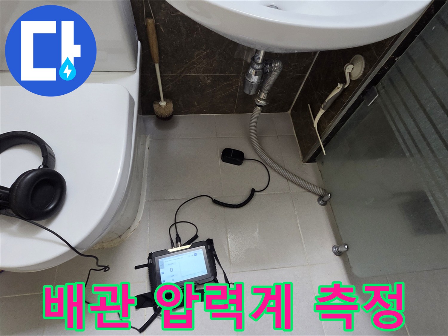 화장실 바닥에 설치된 배관 공압 테스트용 장비들