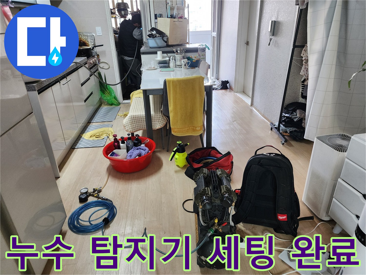 거실 바닥에 놓인 누수 진단용 가스 탐지기와 압력 테스트 장비