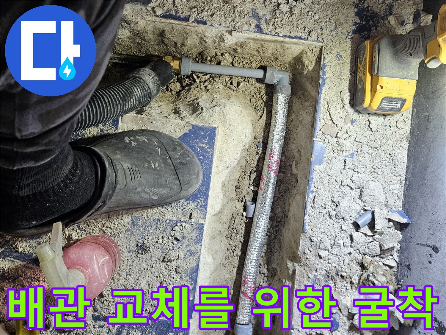 바닥 타일 아래 드러난 부식된 배관과 작업 도구들