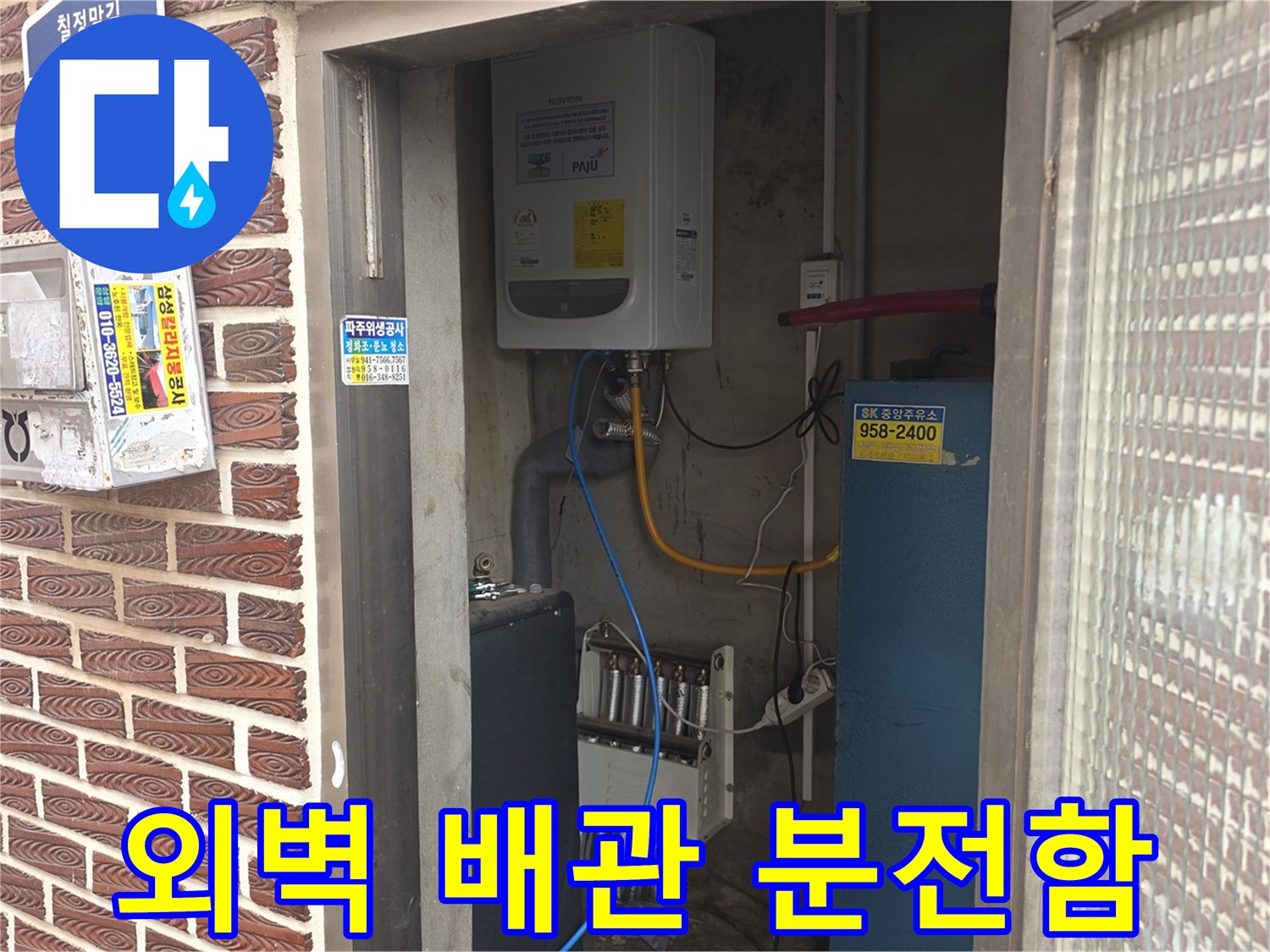 붉은 벽돌 외벽에 설치된 수도 밸브와 전기 배선 함체