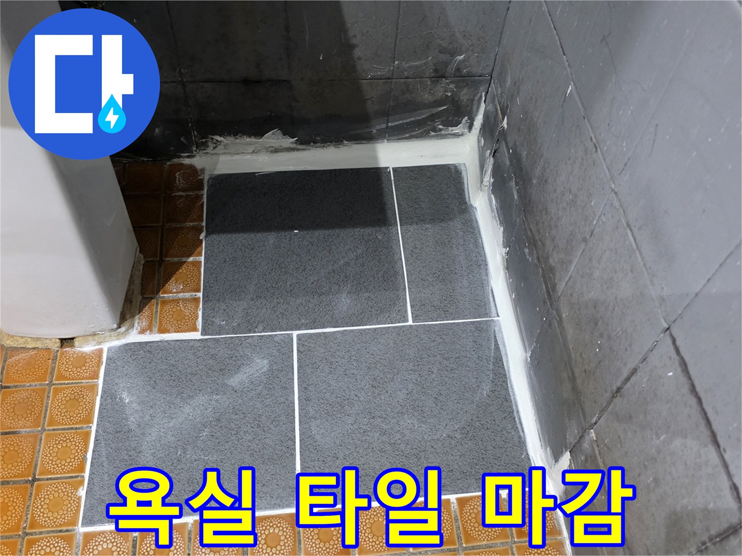 새로 시공된 어두운색 타일과 기존 바닥의 연결 부위
