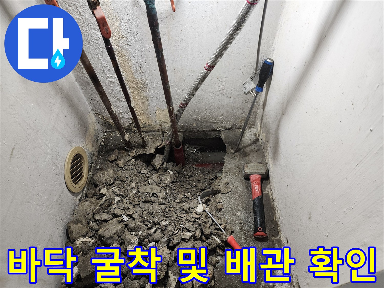 콘크리트 파쇄 후 드러난 배관과 작업 도구들