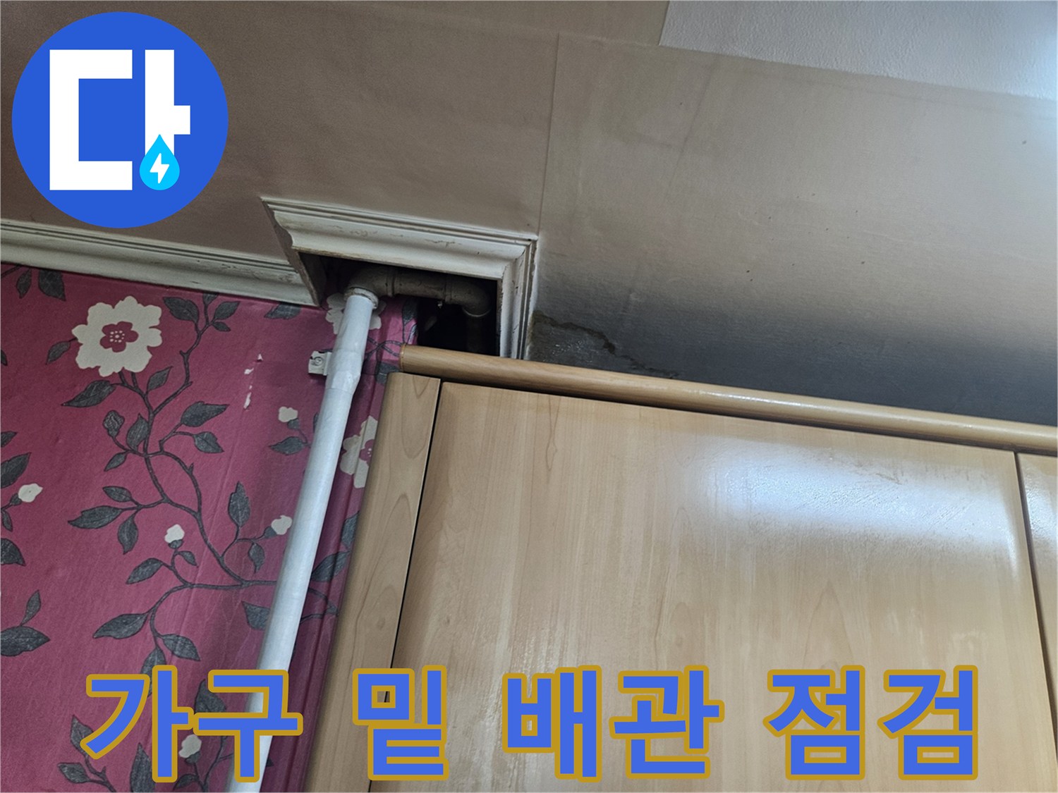 싱크대 하부 틈새로 보이는 배관 연결 상태 사진