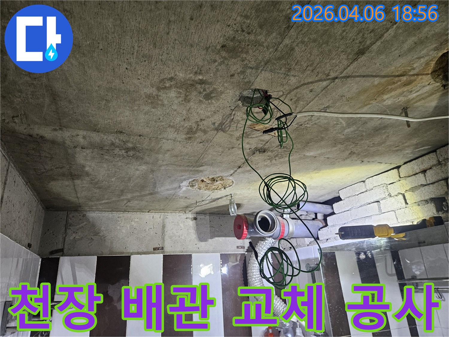 콘크리트 천장 아래-노출된 배관과 전기선-누수 탐지 후 교체 준비 현장
