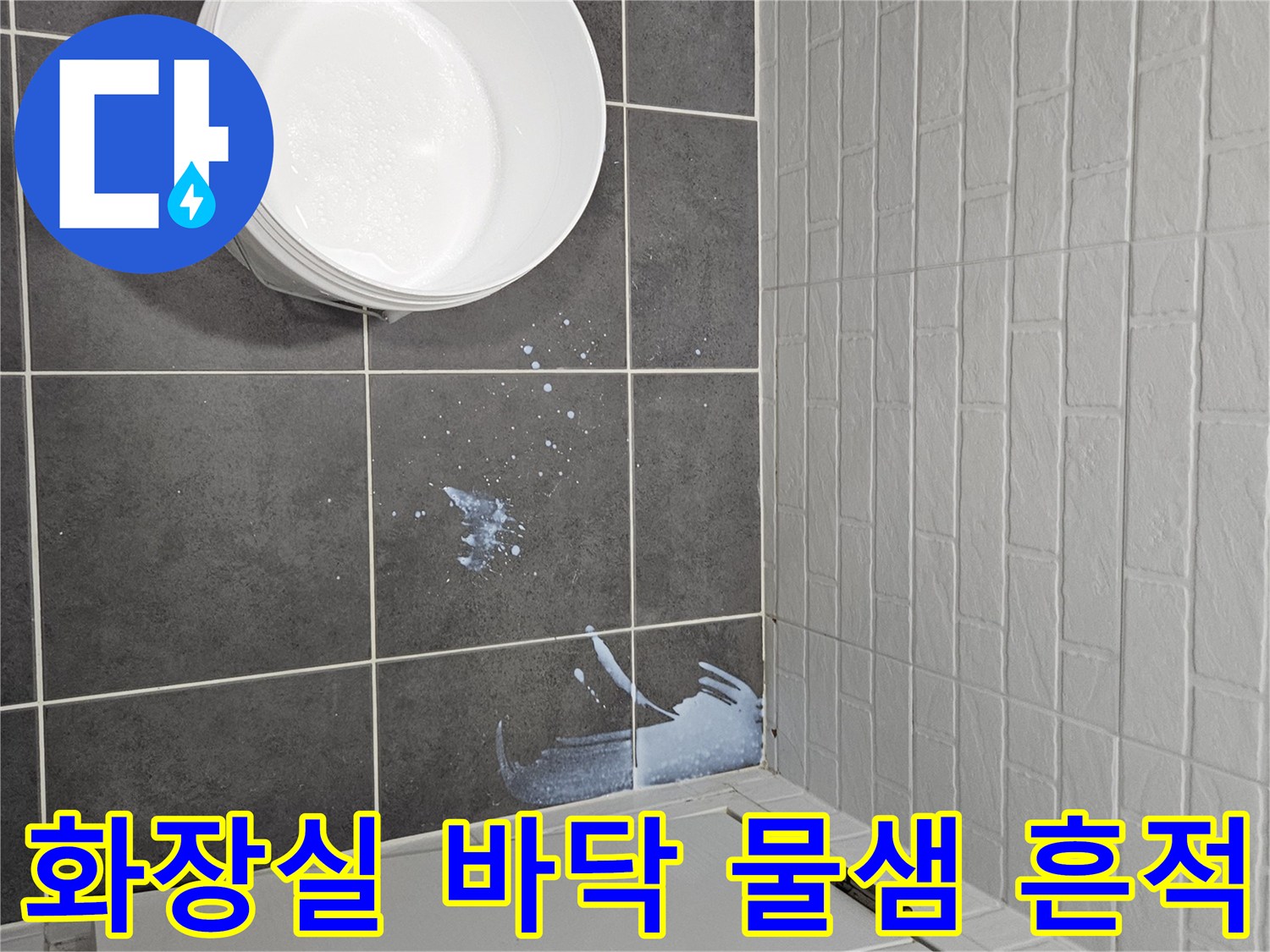 어두운 색의 욕실 타일과 작업용 양동이 사진