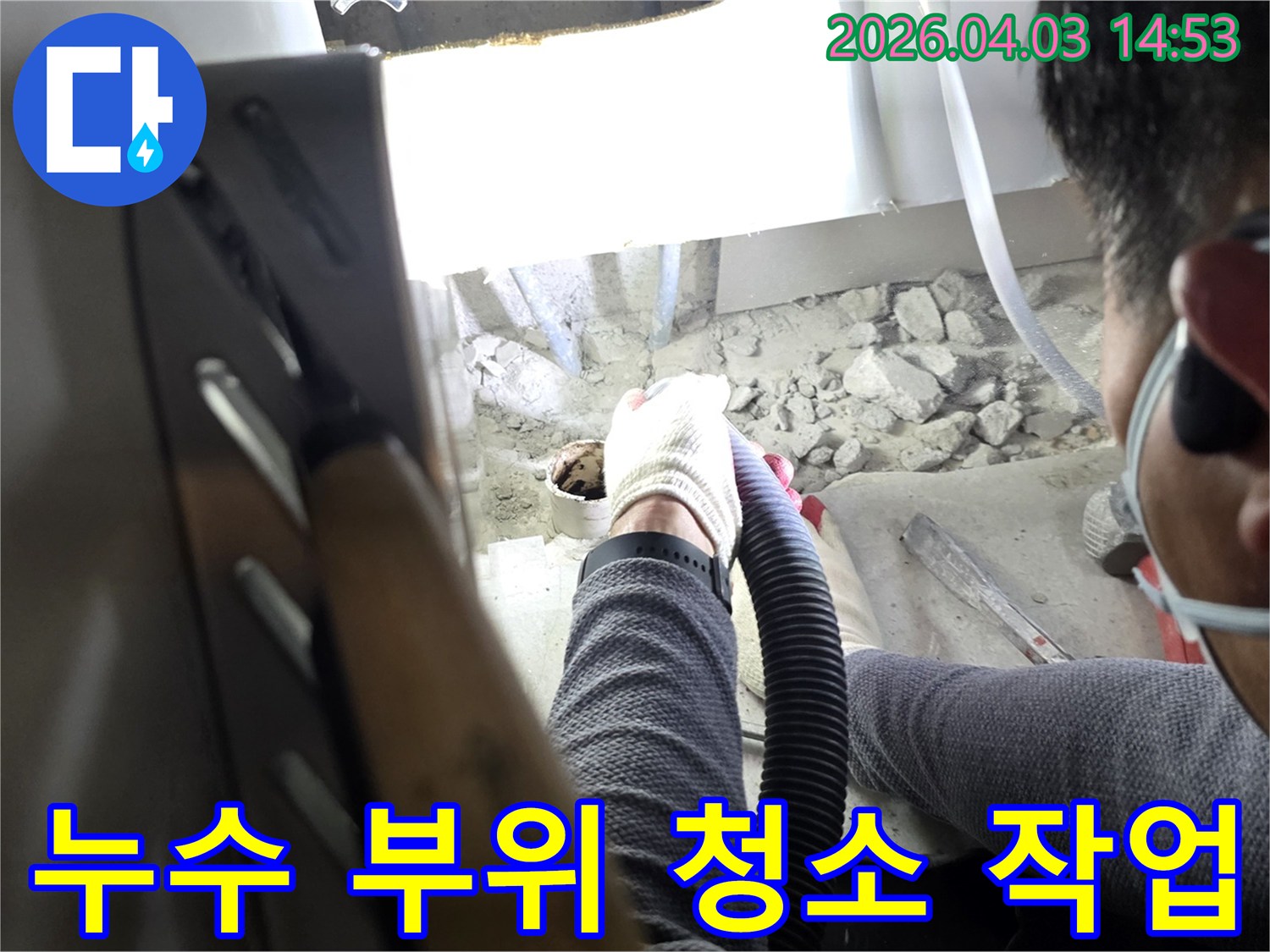 누수 지점 파쇄 후-작업자가 흡입기로 주변을 깨끗하게 청소하는 장면