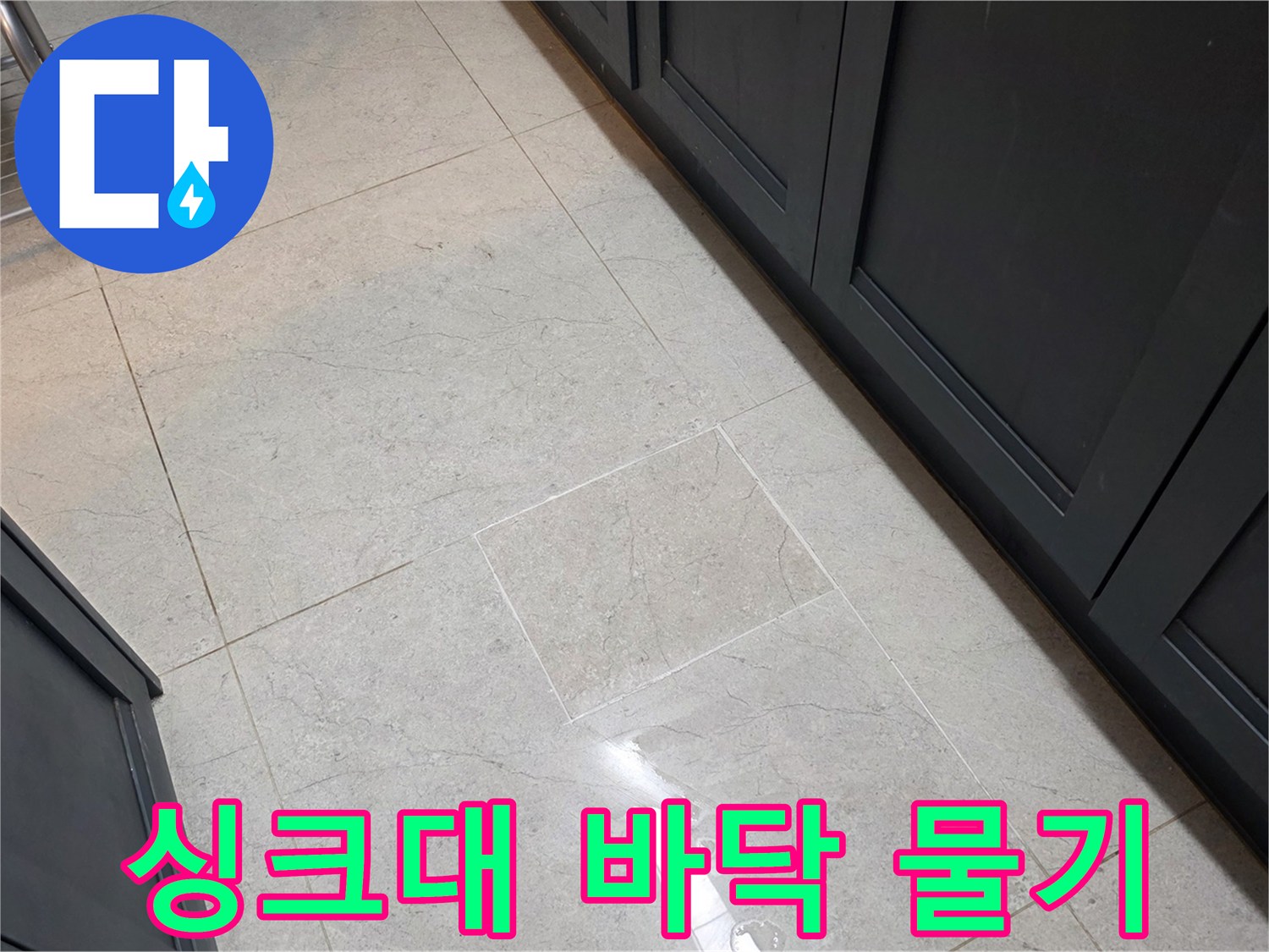 싱크대 하부장 앞쪽 타일 바닥에 물기가 고여 있는 모습