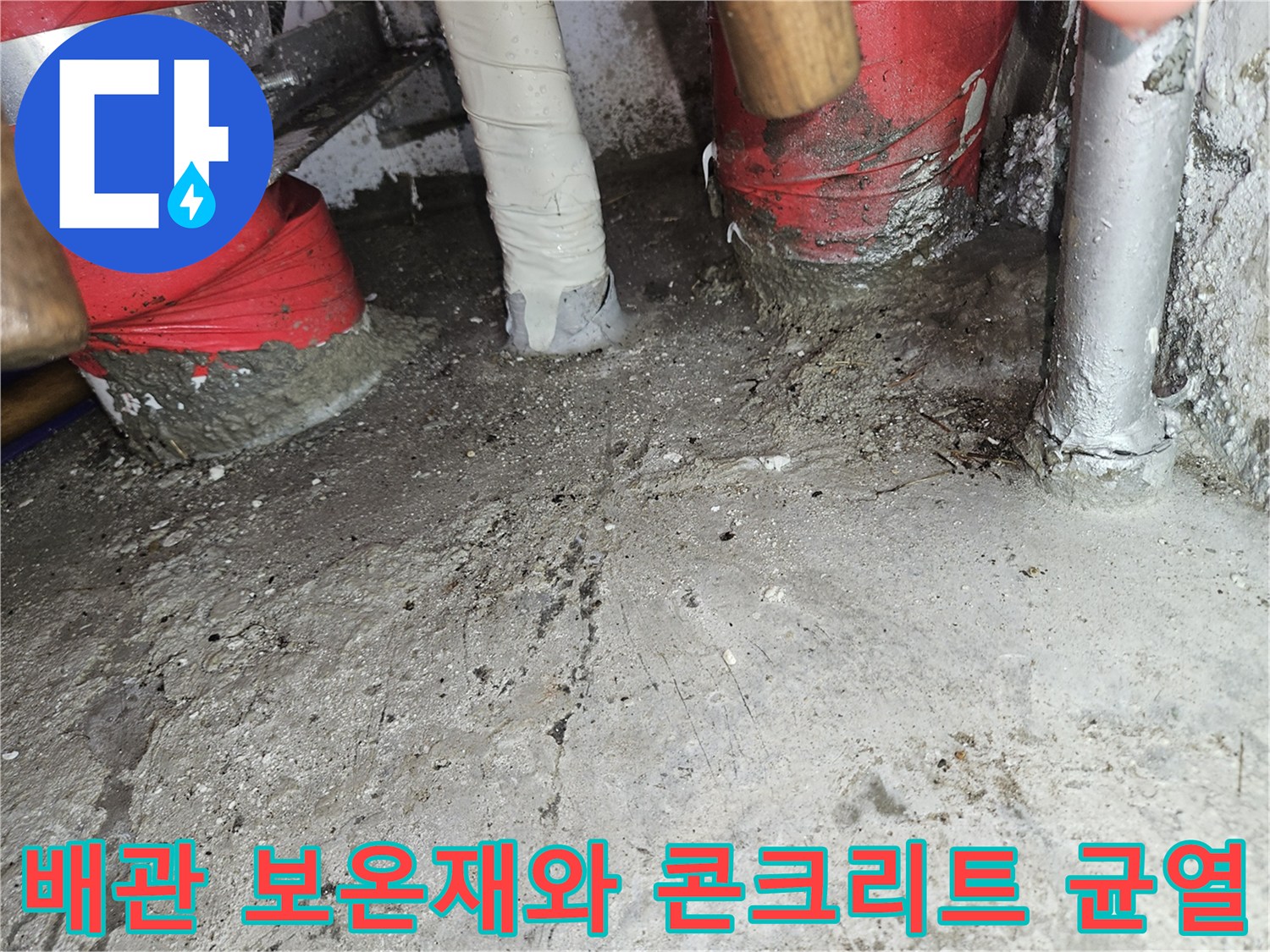 천장 콘크리트 면의 균열과 빨간색 보온재가 감싸진 배관 상태를 근접 촬영한 모습
