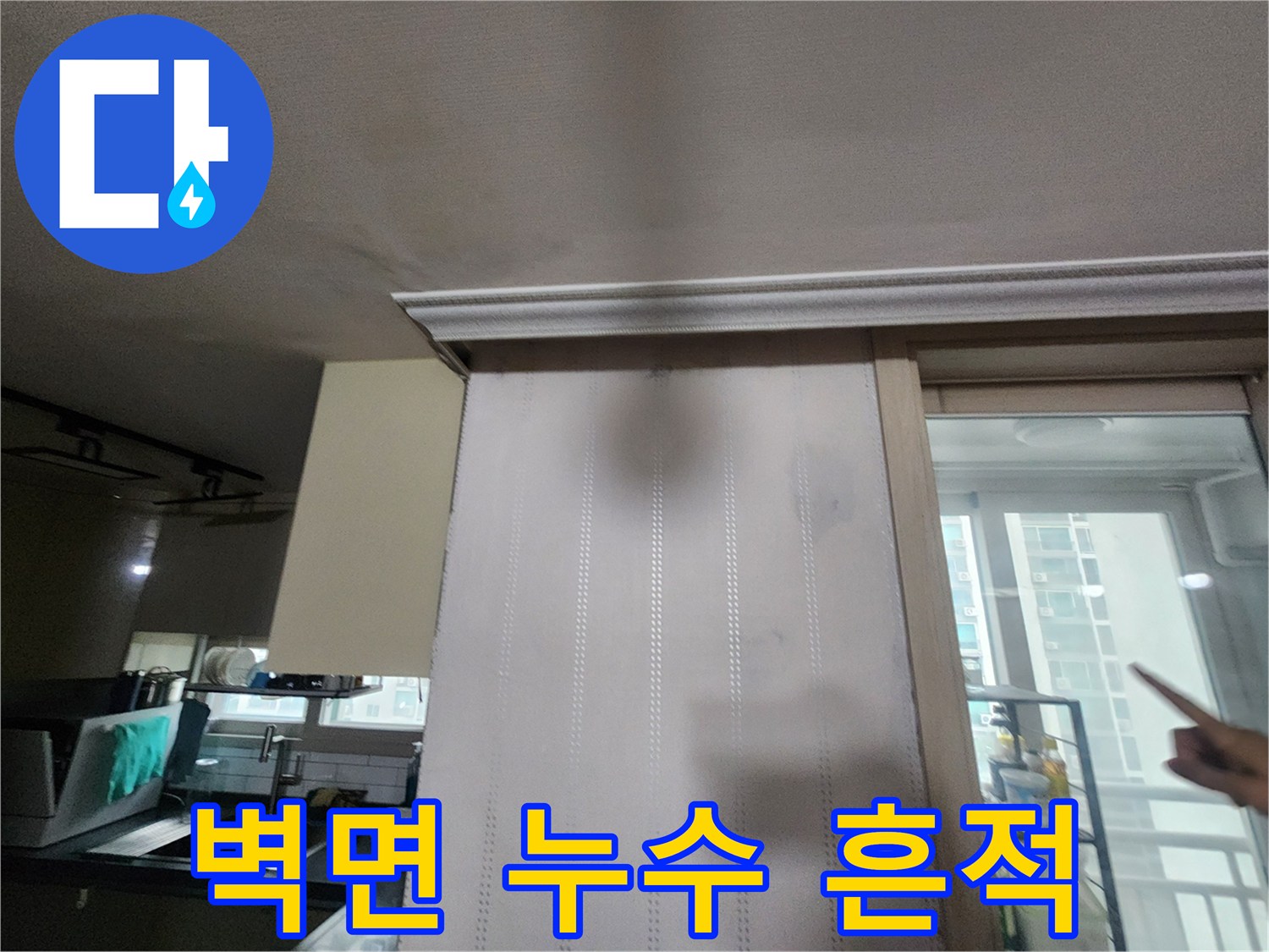 벽지 표면에 나타난 짙은 색의 누수 얼룩 부위