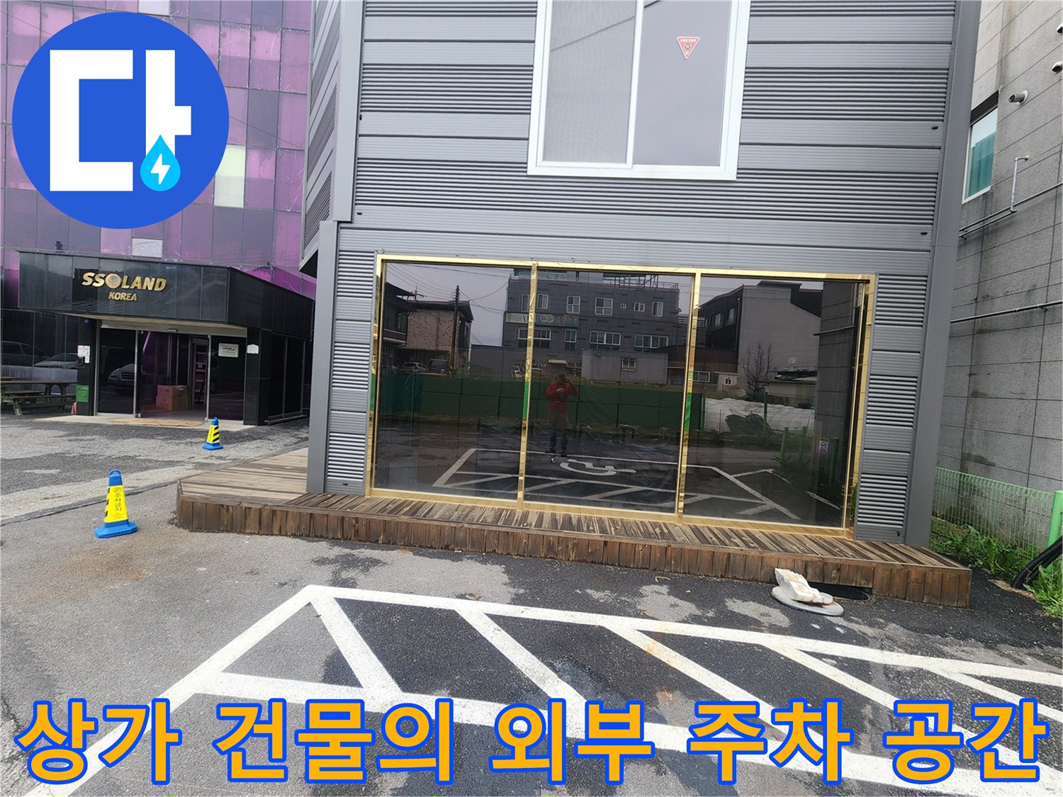 상가 건물 앞 아스팔트 주차 구역 전경