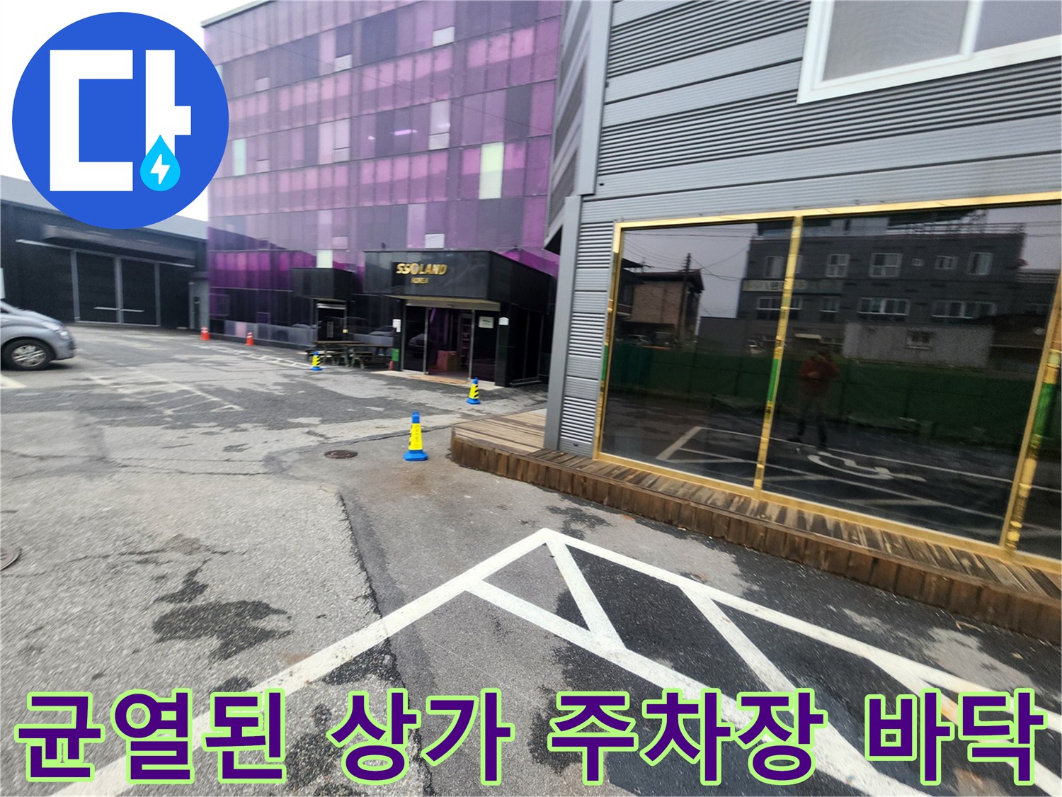 아스팔트 균열과 함께 지면이 내려앉은 상업용 건물 주차장