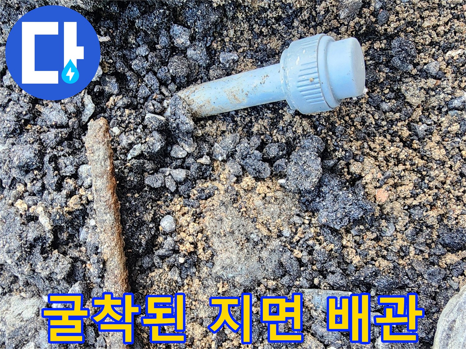 파손된 배관 부속-아스팔트 아래 노출된 상태