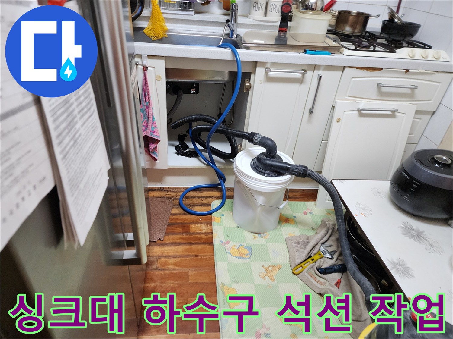 싱크대 배수 호스에 연결된 석션 튜브가 이물질을 빨아들이는 장면입니다.