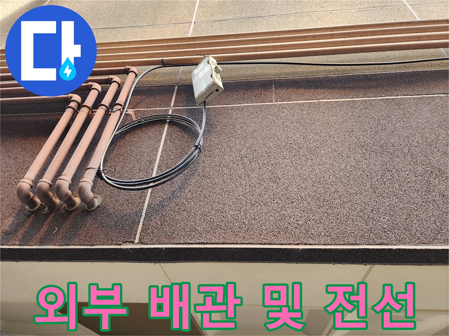 건물-외벽에-노출된-다수의-배관과-전기-케이블