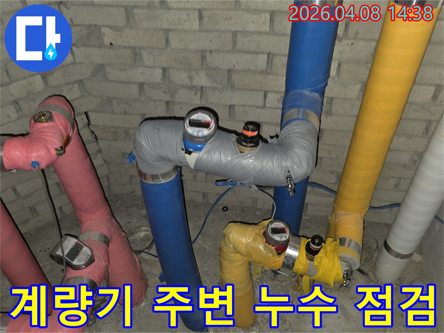 건물 지하 배관에 설치된 계량기 주변에서-누수 발생 여부를-전문가가 정밀하게 점검하는 모습