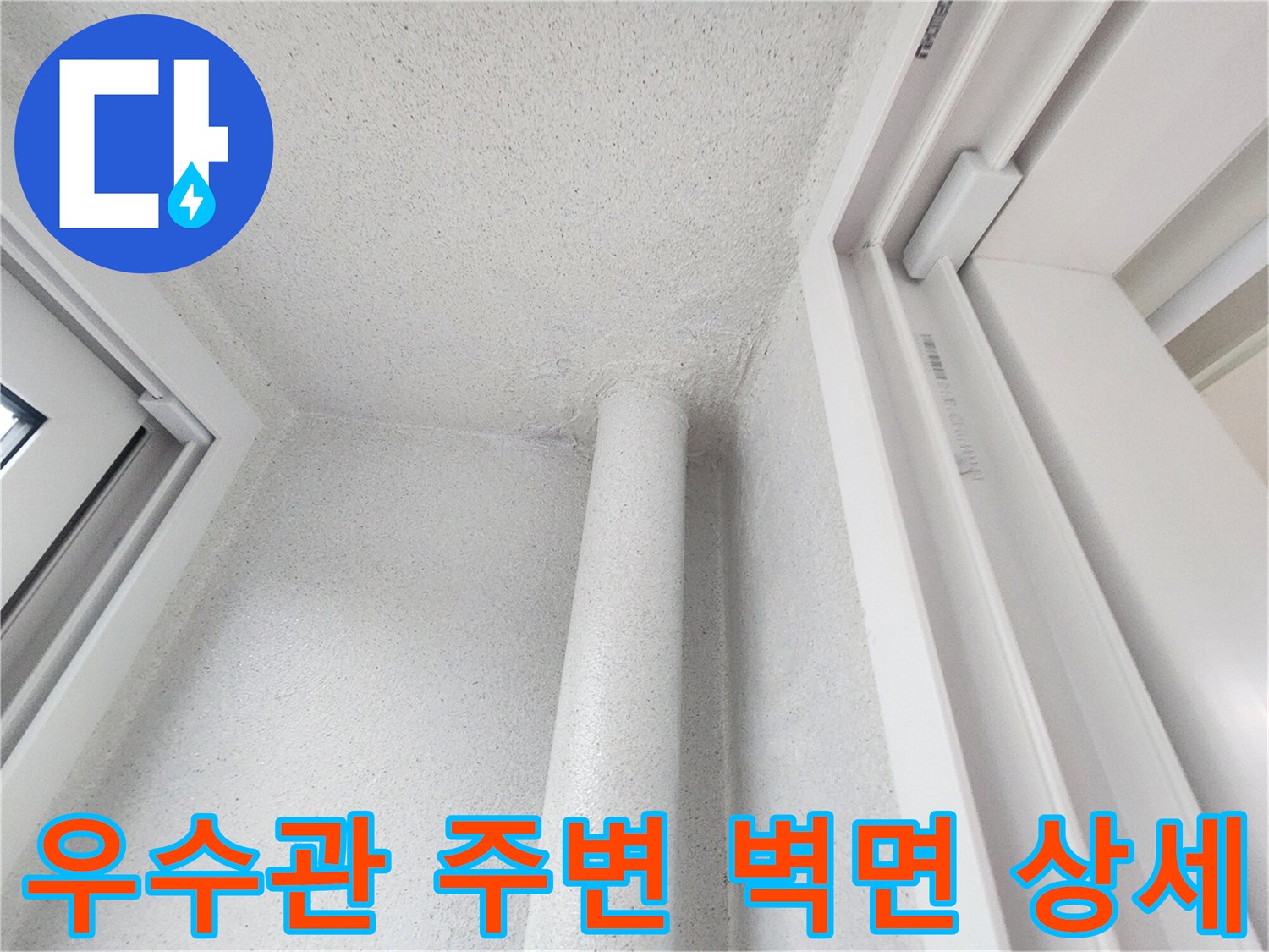 하얀색 배관과 벽면이 만나는 지점의 근접 사진