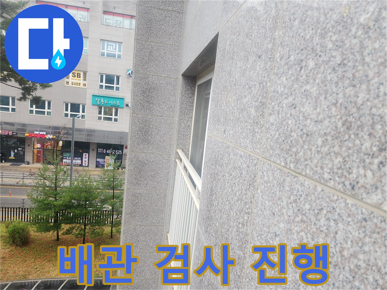 건물 외곽과 배관 연결 부위의 상태를 점검하는 작업 현장입니다.