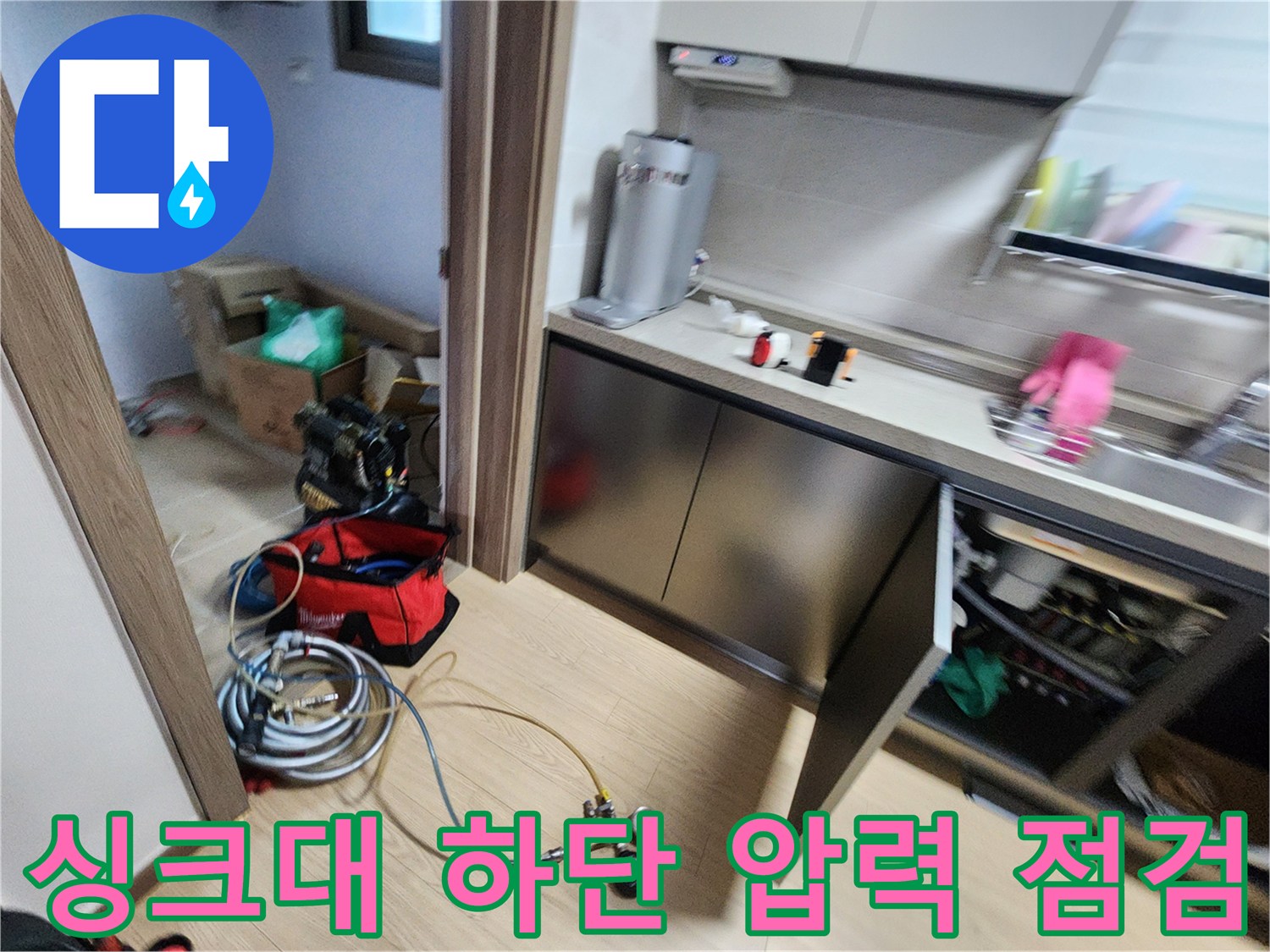 싱크대 밑 공간에 설치된 배관 누수 탐지용 압력계와 호스 연결 모습