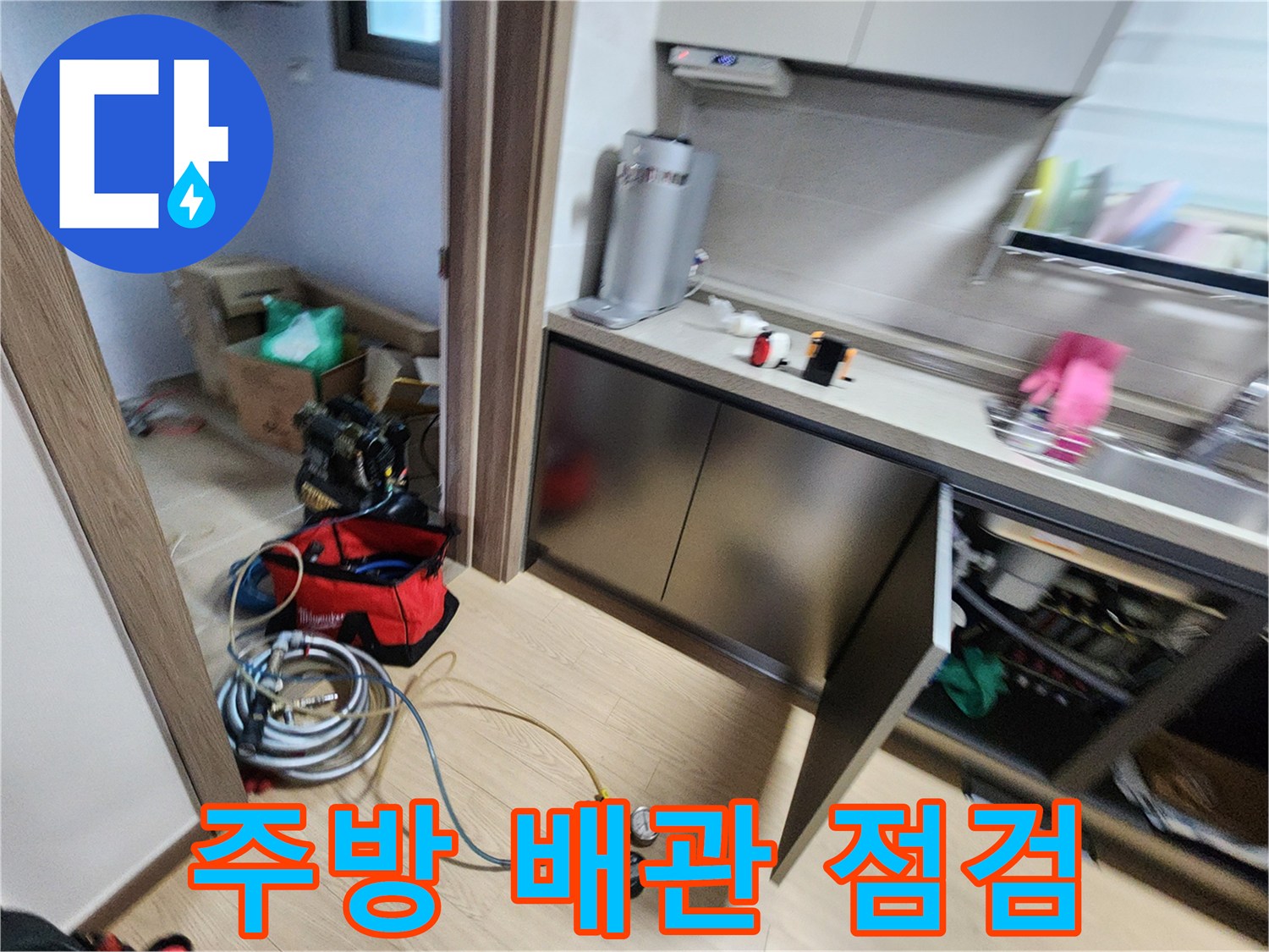 싱크대 하부장 안쪽에서 진행 중인 배관 압력 측정 작업