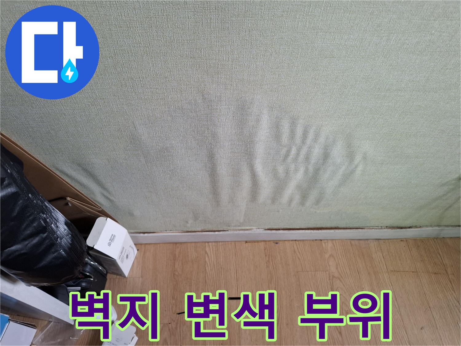 물에 젖어 어둡게 변한 벽지 하단부