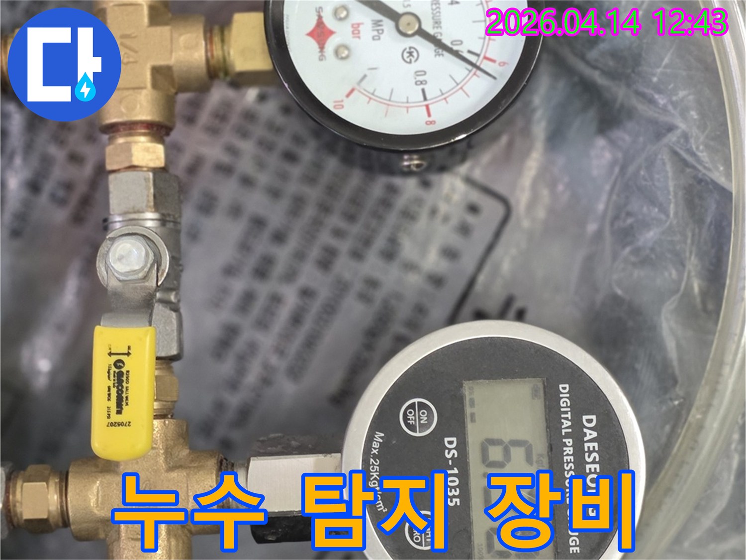 누수 발생 여부를 확인하기 위해 배관에 연결된 전문적인 압력 측정 장비의 모습입니다.