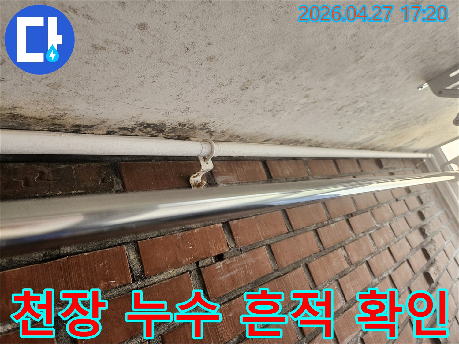 천장과 벽이 만나는 지점에서-누수로 인한 곰팡이와-녹슨 배관 지지대가 발견된 모습