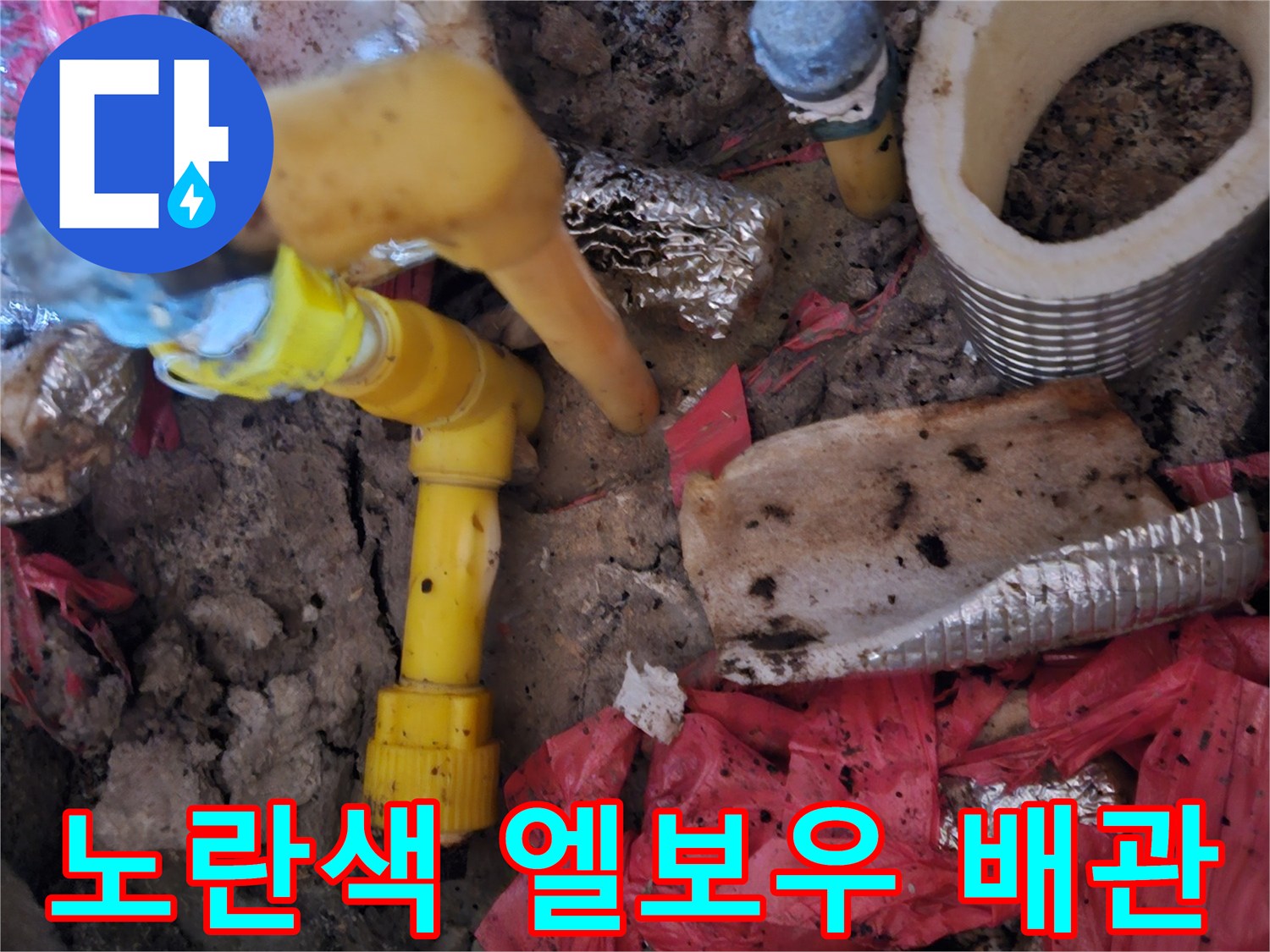 흙과 폐자재 사이로 드러난 노란색 수도 부속품