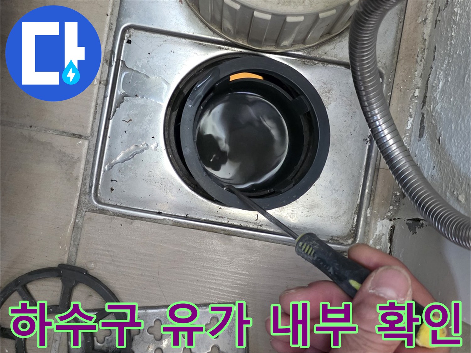 도구를 사용하여 배수구 안쪽을 살피는 작업자 손