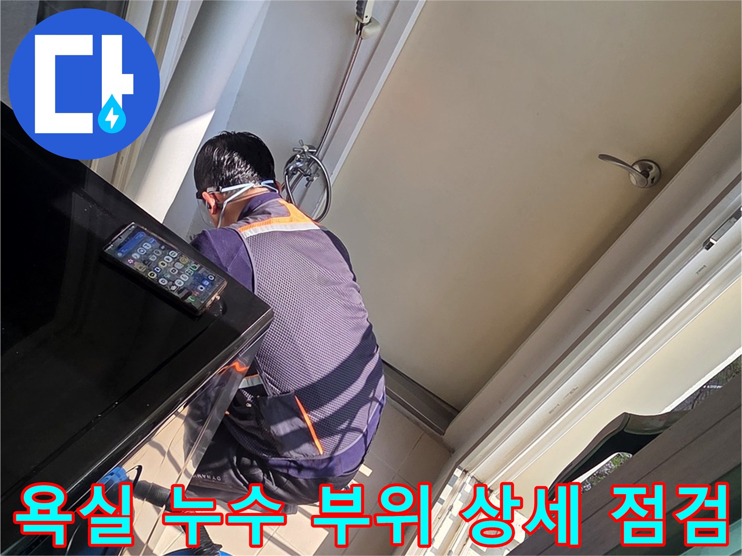 작업자가 욕조와 타일 사이의 결함을 확인하기 위해 숙인 모습