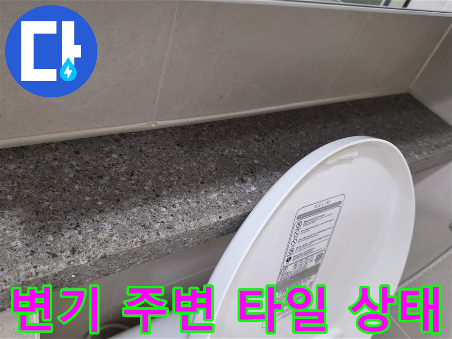 화장실 변기 뒤쪽의 대리석 선반과 벽면 타일 모습