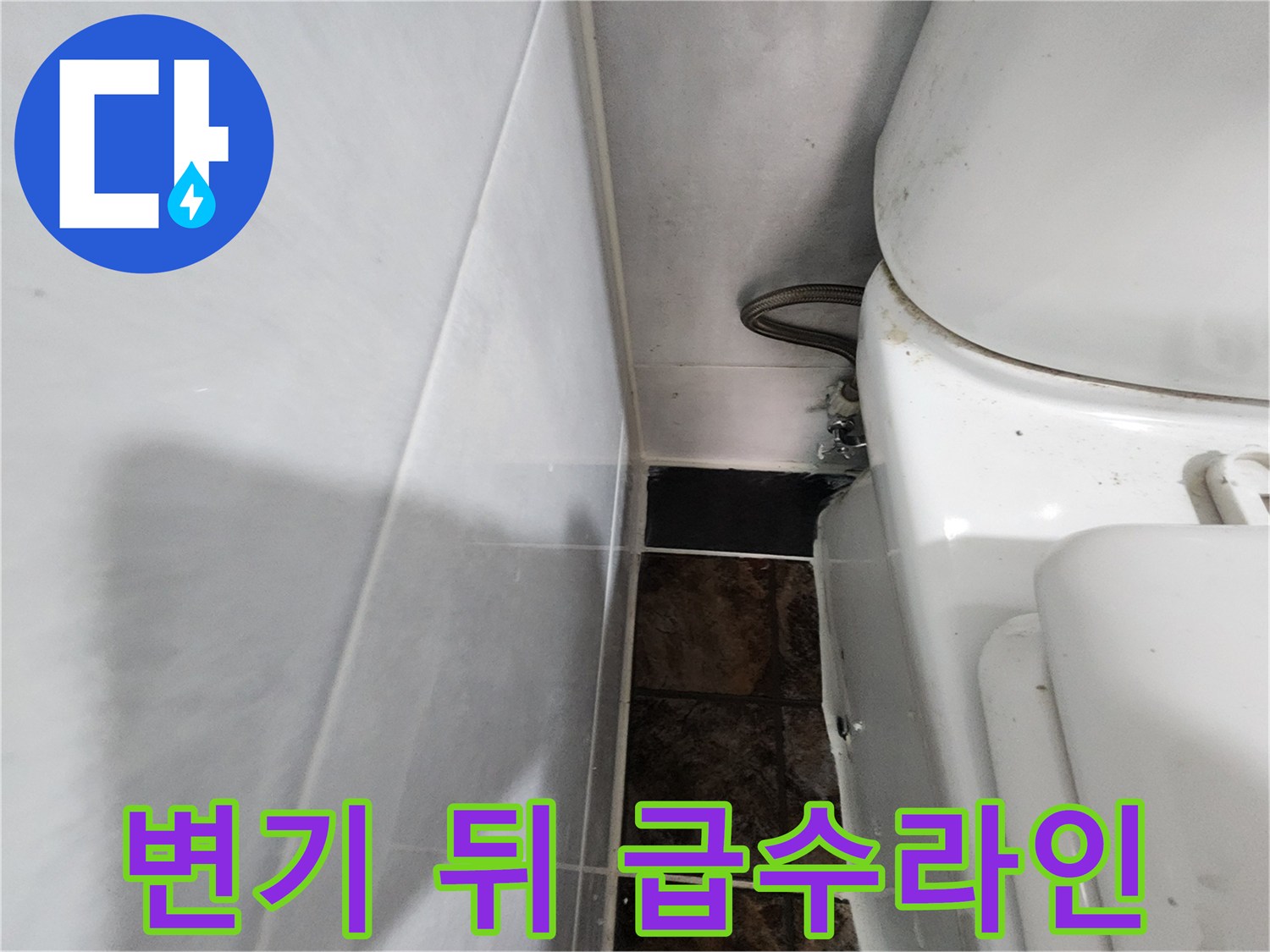 변기 뒷벽에 설치된 은색 금속 소재의 급수 배관 부위