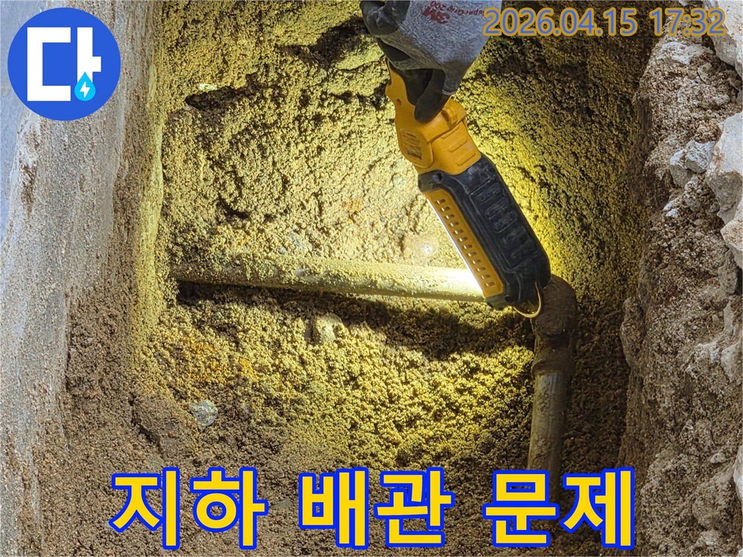전문가가-손전등으로-땅속에-묻힌-지하-배관의-누수-지점을-정확히-확인하며-문제-해결을-위한-계획을-수립하고-있습니다.