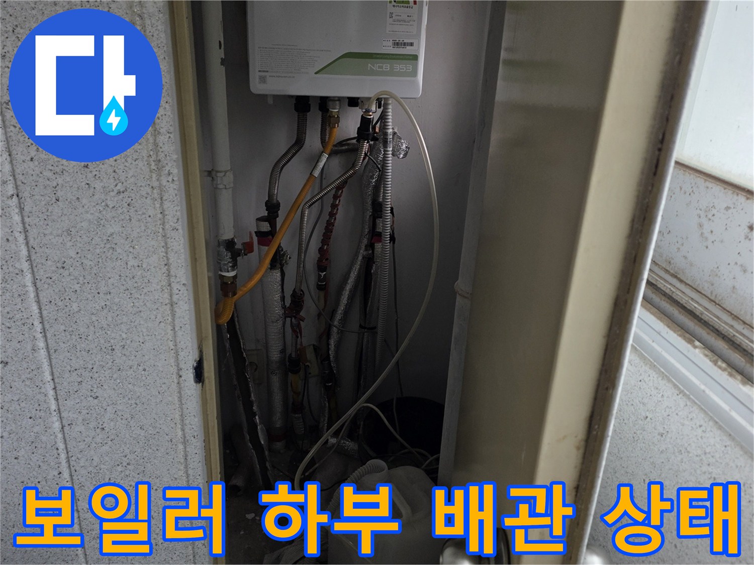 보일러 아래쪽의 금속 및 플라스틱 배관 연결 모습