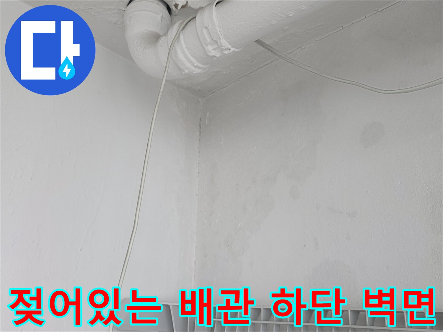 하얀색 배관 아래쪽 벽면에 나타난 수분 침투 및 변색 부위