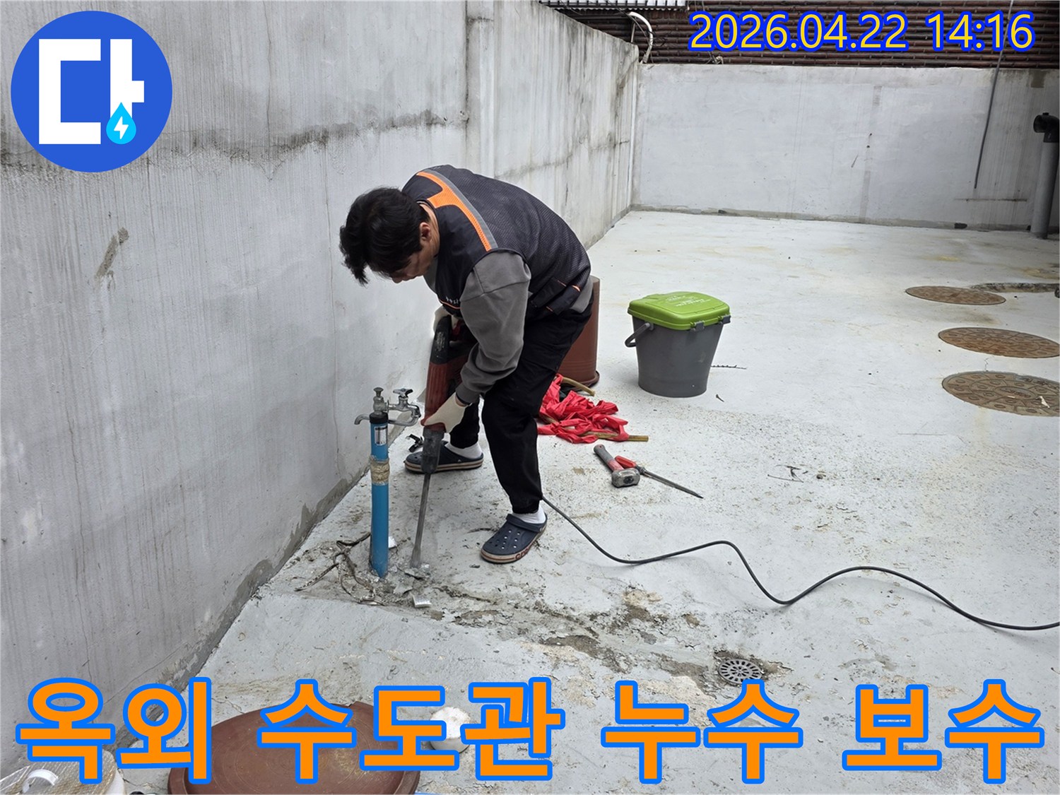 누수 기술자가 옥외 수도관 누수 지점을 찾아 콘크리트를 파쇄하는 작업 현장
