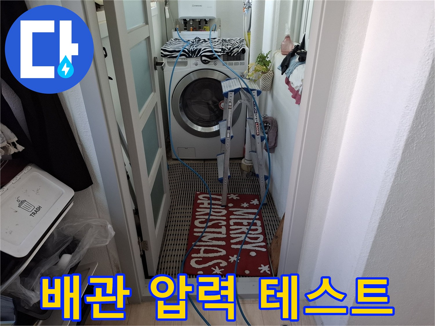 세탁기 근처 배관에 파란색 호스를 연결하여 압력을 측정 중입니다.